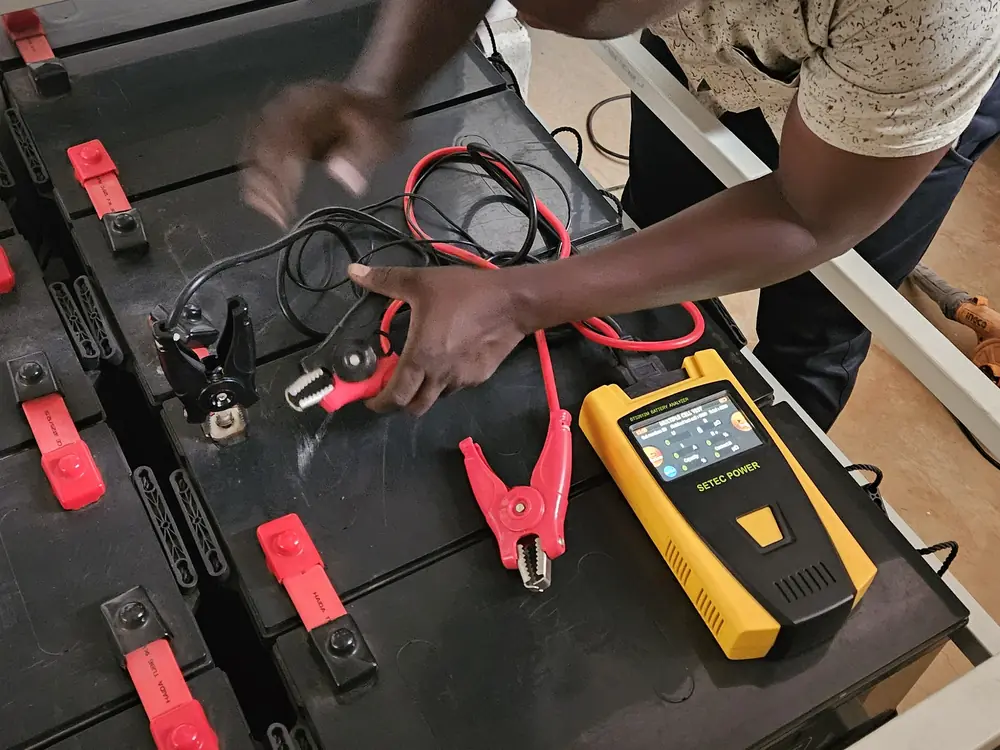 Technician testing UPS battery terminals